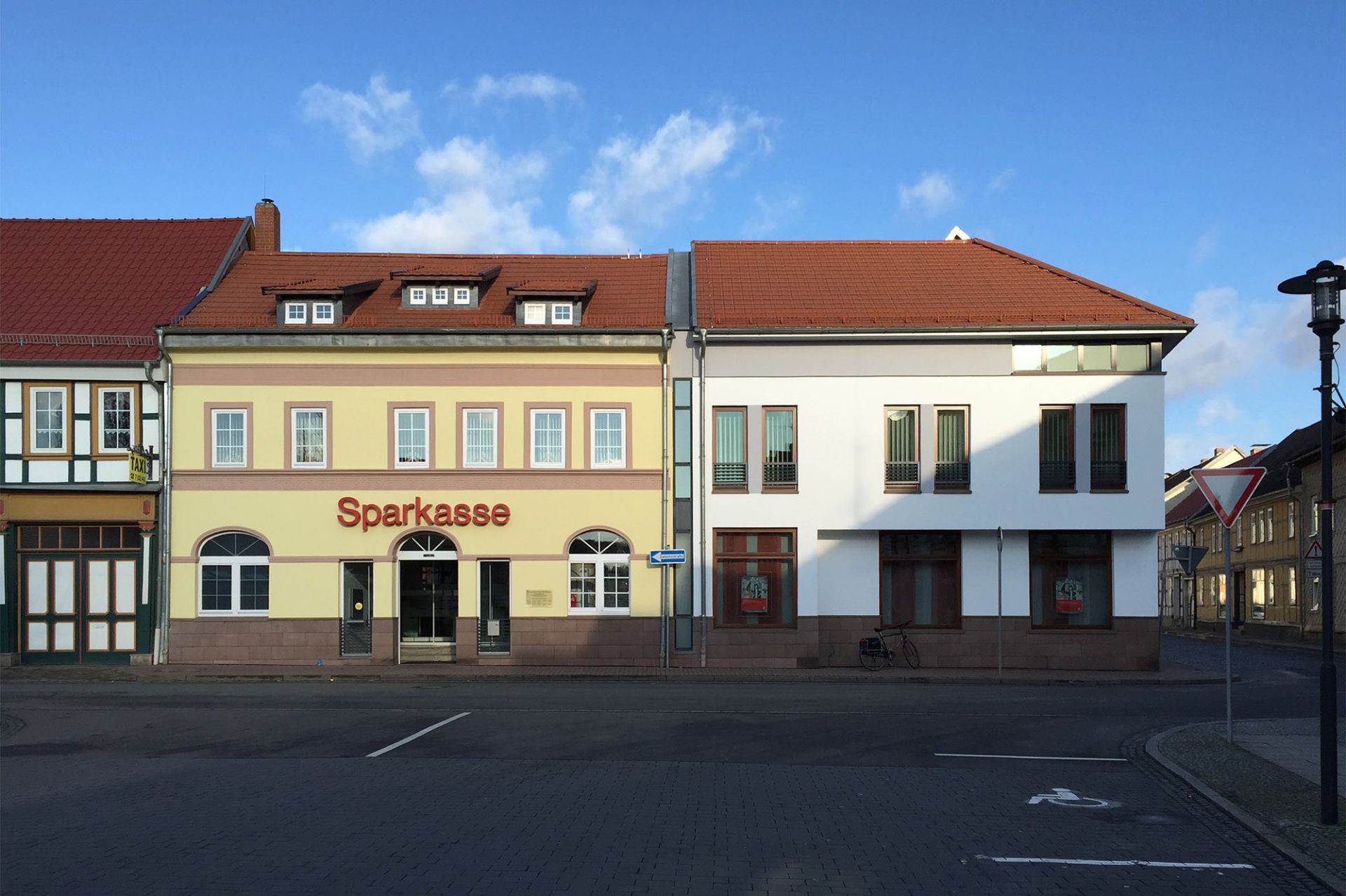 Eckbebauung Filiale der Kreissparkasse Nordhausen mit Sandsteinsockel, bodentiefen Fenstern und Glasfuge zum Nachbargebäude, Architekt Michael Flagmeyer